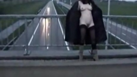 Exhibitionist wife in stockings and long coat flashing motorists on a bridge